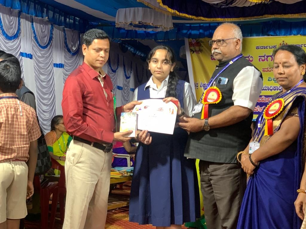Hiranmayi S. of Grade 9 receiving a prize at the drawing competition