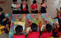 Kindergarten children reading picture books together